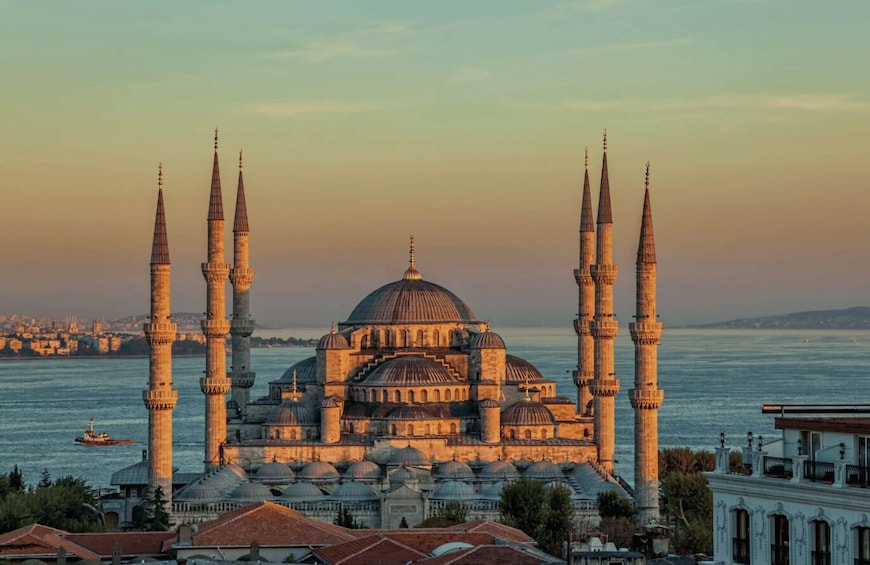 A historic mosque with multiple minarets and domes, overlooking a body of water. 5