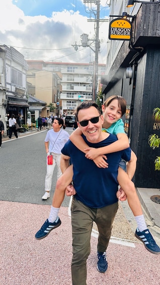 A man carrying a child on his back on a city street. 4