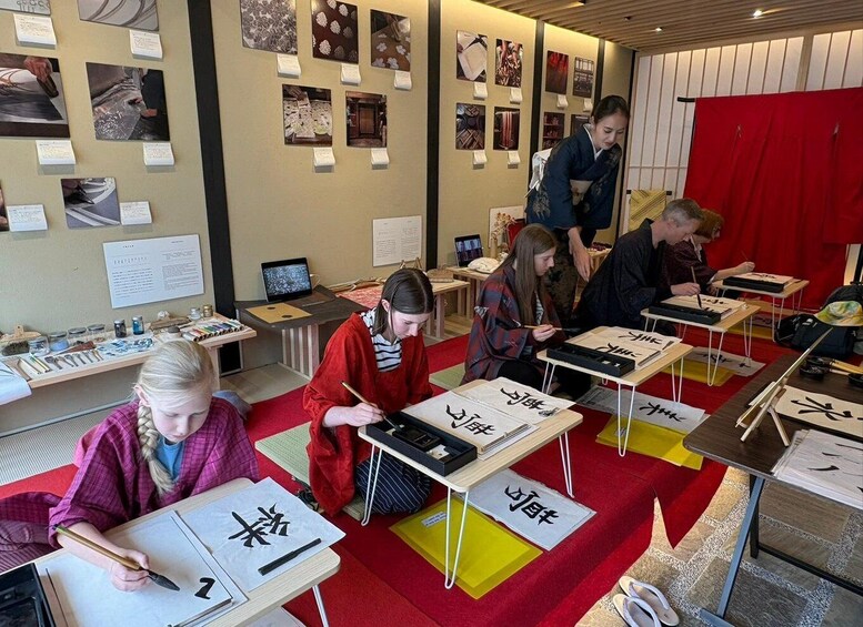 A calligraphy class with students practicing on paper with Chinese characters. 3