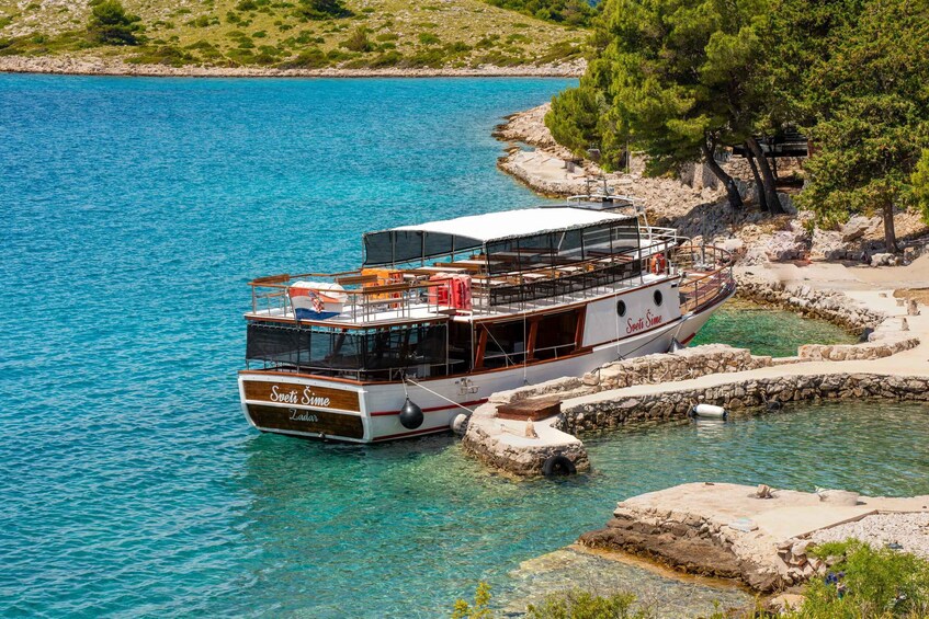 A boat named 'Sveti Simeon' docked at a rocky shore with clear turquoise water. 5