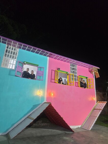 A brightly colored house with two visible windows, each with a yellow frame. 5