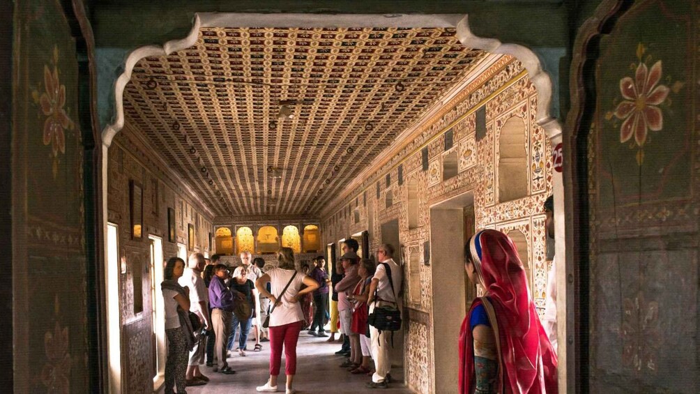 A corridor with ornate arches and detailed wall carvings. 4