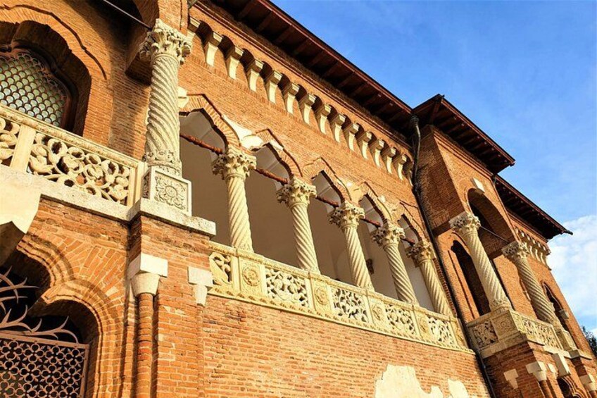 Un edificio histórico con detalles en ladrillo ornamentados, grandes columnas y arcos decorativos. 5