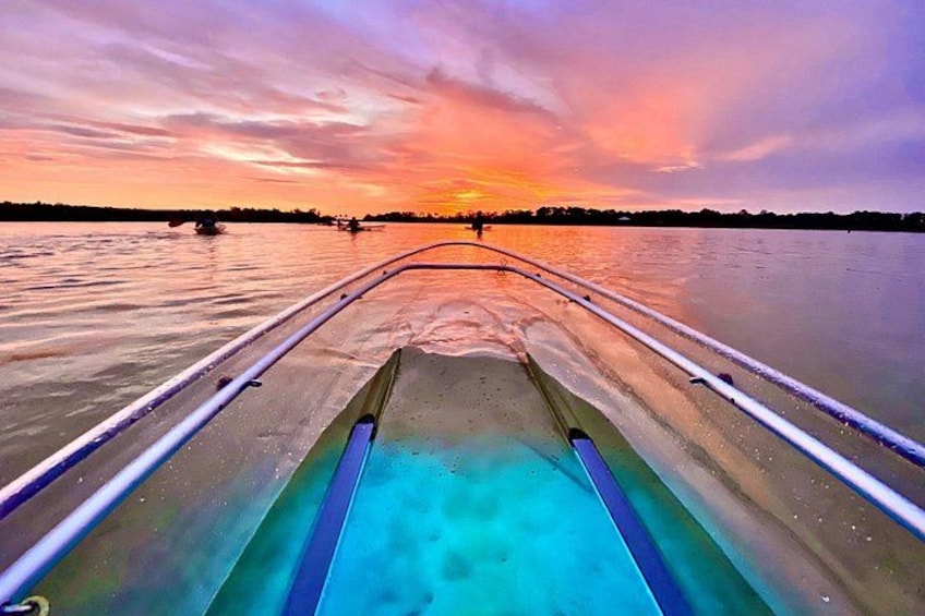 A boat on calm water during sunset with a colorful sky. 1