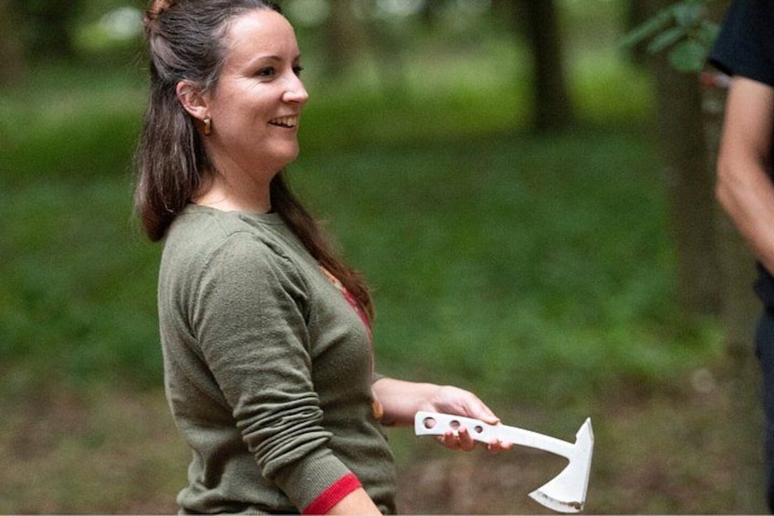 A person holding an axe in a wooded area. 2