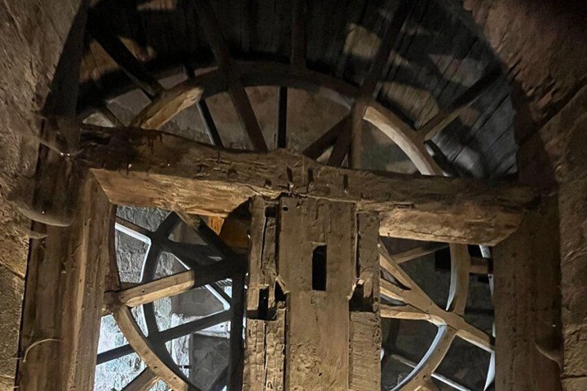 Una struttura in legno con una grande ruota e travi. 4