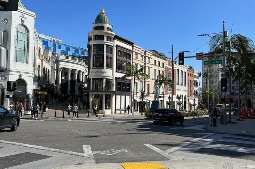 A busy intersection with traffic lights, pedestrians, and historic buildings. 3