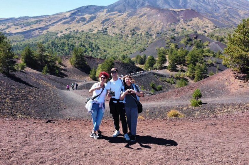 Three people standing on a dirt path with a mountainous landscape in the background. 5