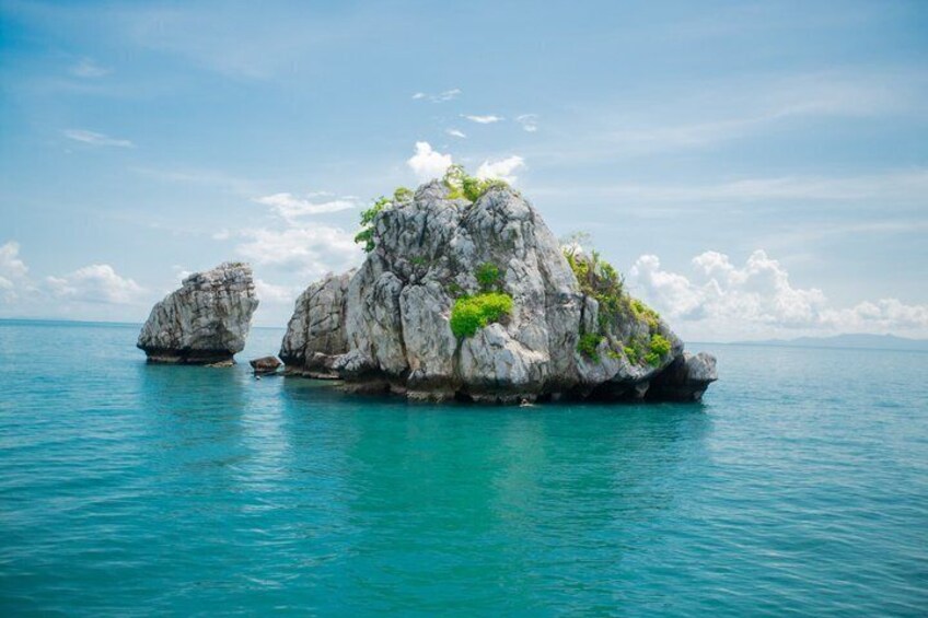 Une île rocheuse, dotée d’une végétation luxuriante et bordée d’eaux turquoise et paisibles. 3
