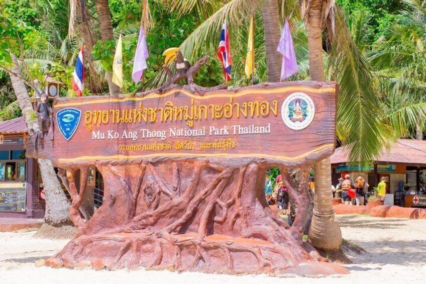 Une pancarte en bois avec des caractères thaïlandais et le logo du parc national de Mu Ko Ang Thong. 2