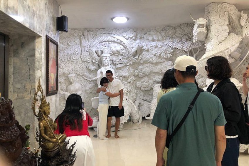 Un grupo de personas dentro de un templo con tallas y estatuas elaboradas. 2