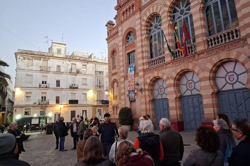 A group of people gathered in a public square with historic buildings in the background. 4