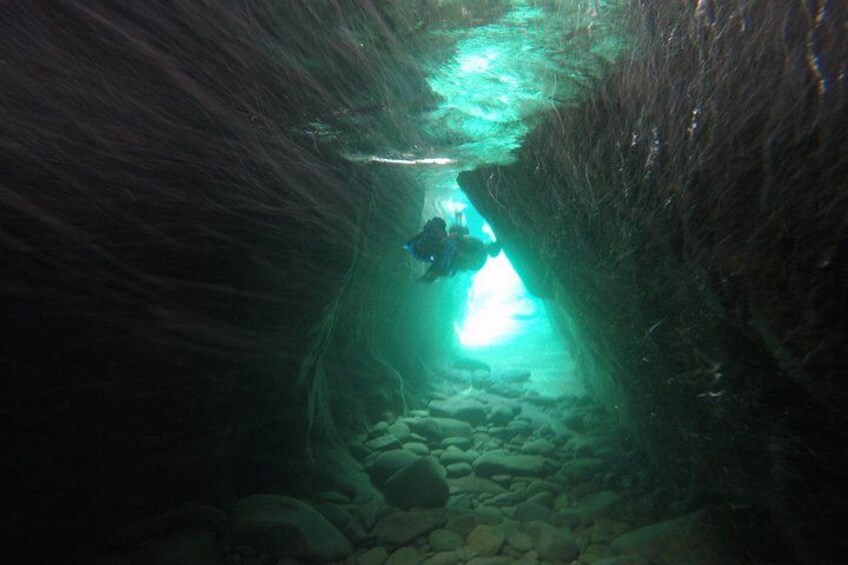 Ein Unterwassertunnel mit einem Taucher und einer Lichtquelle. 4