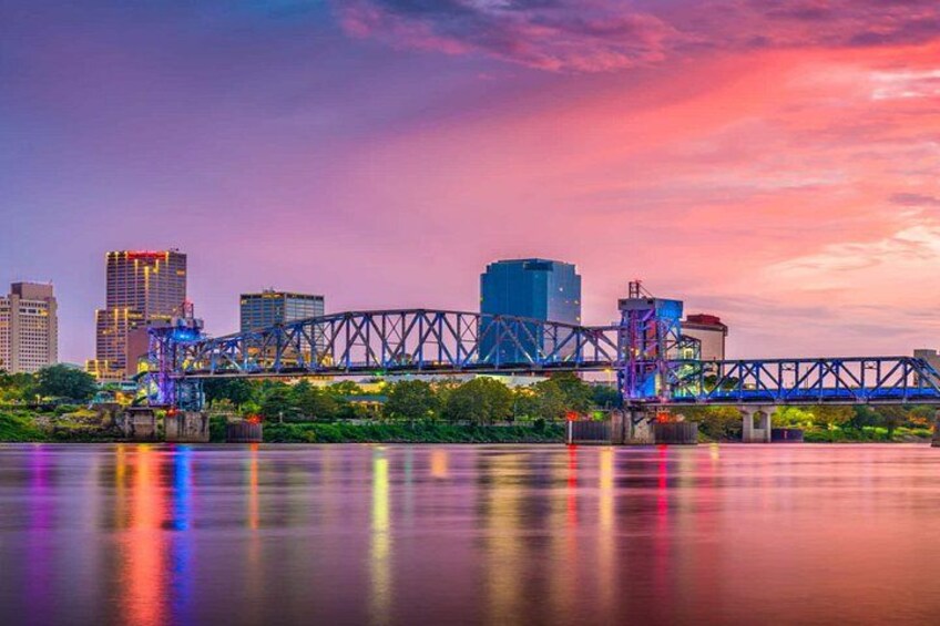 A city skyline with a prominent bridge reflecting colorful lights on a body of water. 2