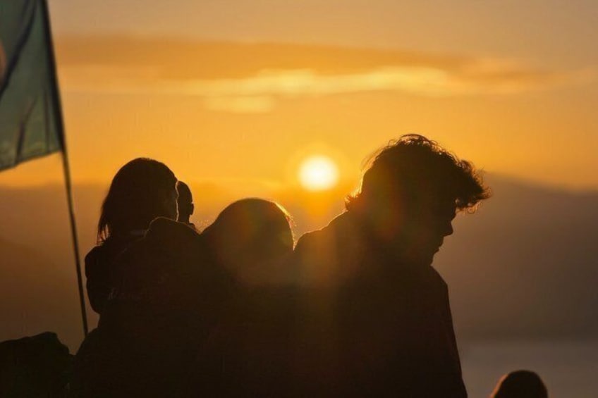 A sunset with a silhouette of a person and a flag. 2
