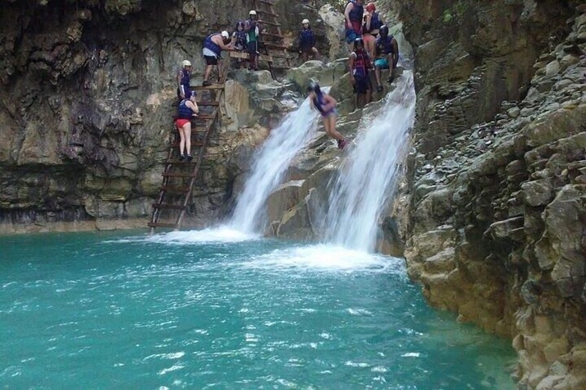 Une cascade où l'on voit des personnes escalader une paroi rocheuse. 3