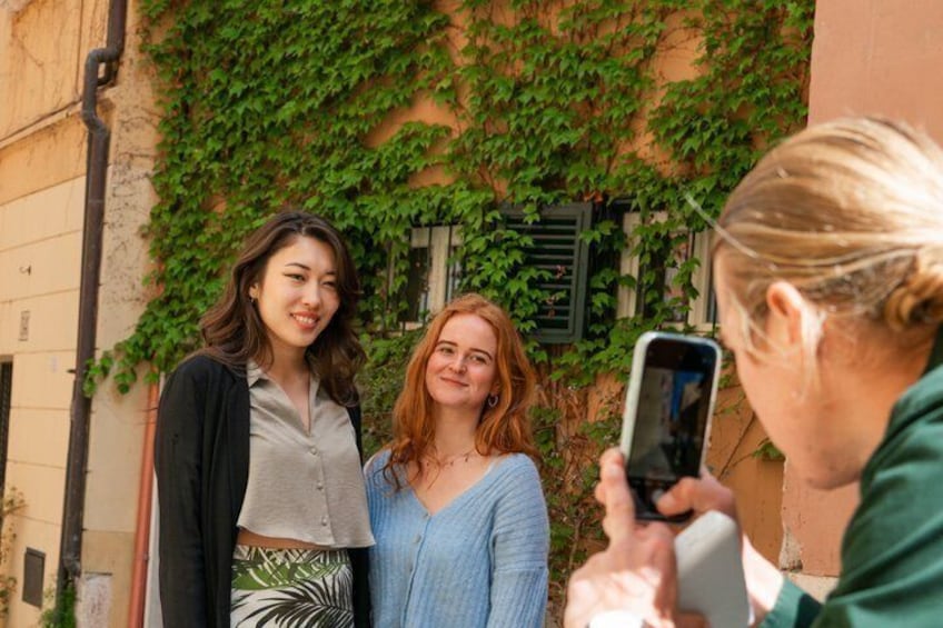 Two people standing in front of a building with green ivy. 5