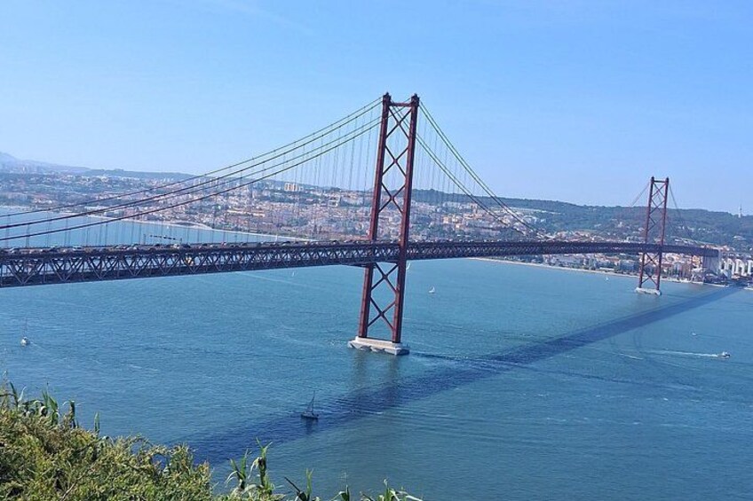 Un puente colgante grande con dos torres, que cruza un cuerpo de agua con un paisaje urbano al fondo. 3