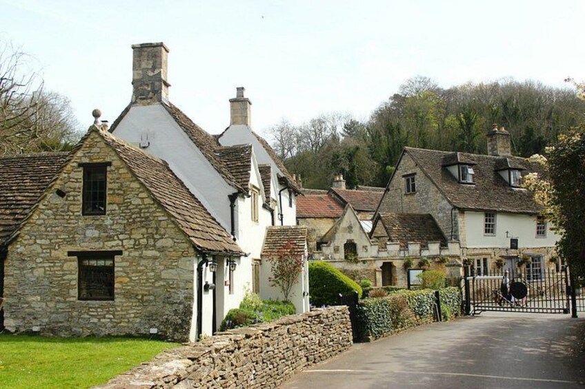 A row of stone and brick houses with a paved road in a rural setting. 3
