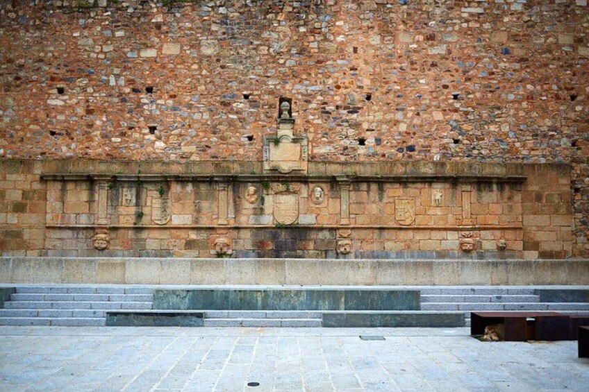 A stone wall with a relief sculpture and steps leading up to it. 5