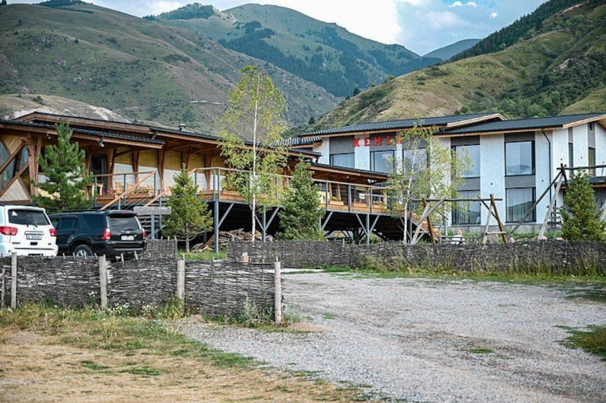 Un chalet de montagne avec une allée en gravier et des voitures garées. 5