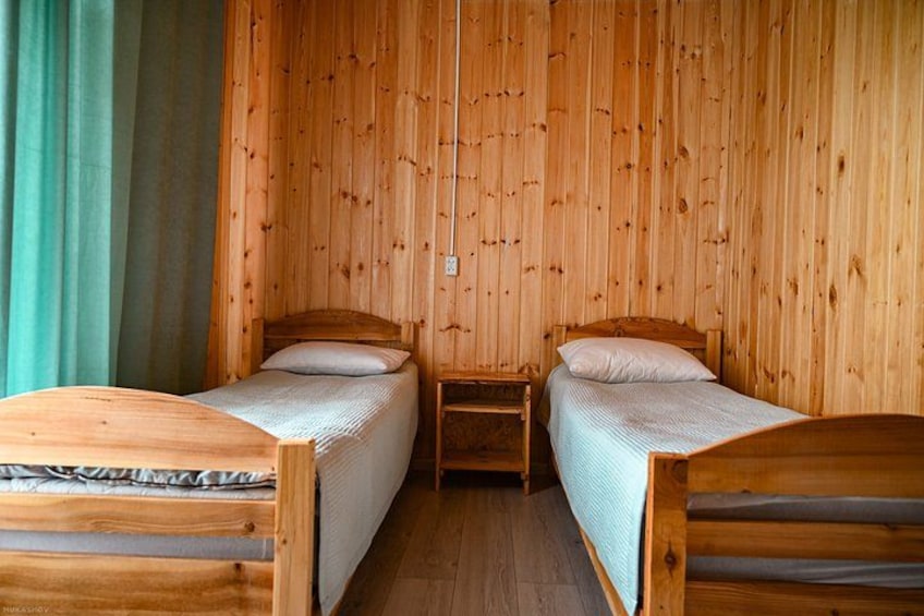 Une cabane en bois avec deux lits superposés et une petite table. 2