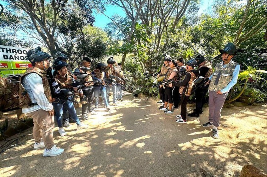 A group of people in tactical gear standing in a line outdoors. 4