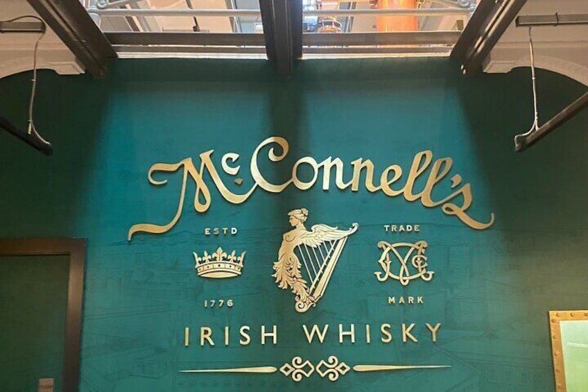 A teal wall with McConnell's Irish whisky branding, including the year 1776 and a harp logo. 5