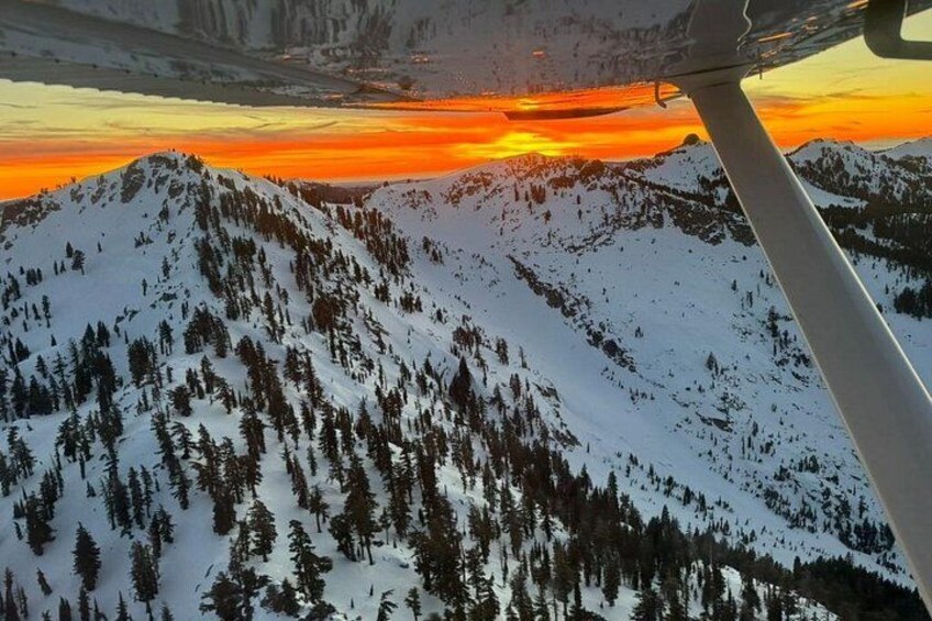 A snow-covered mountain range with a sunset in the background. 2