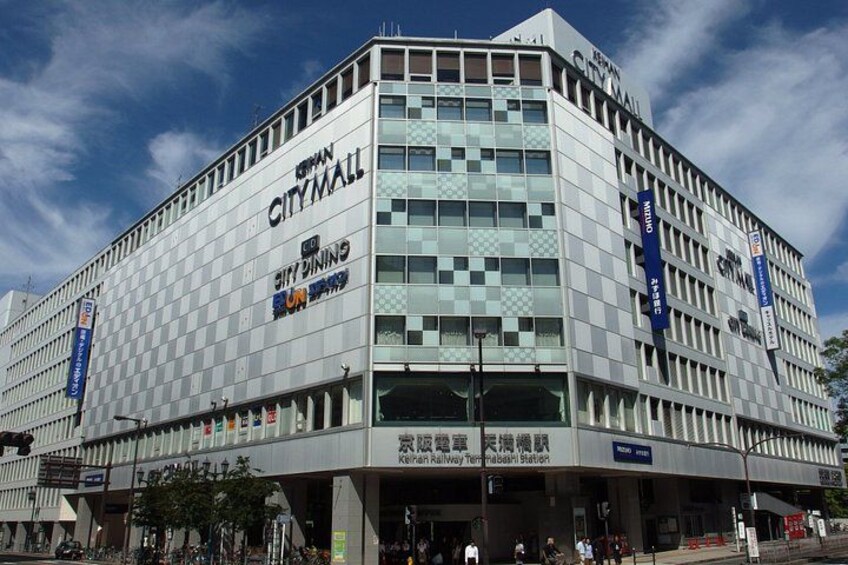 En modern byggnad med skylten CityMall, en fasad med rutmönster och banderoller. 3