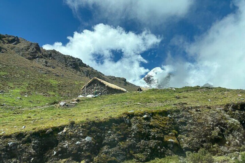 Een berglandschap met een kleine hut en een besneeuwde bergtop op de achtergrond. 1