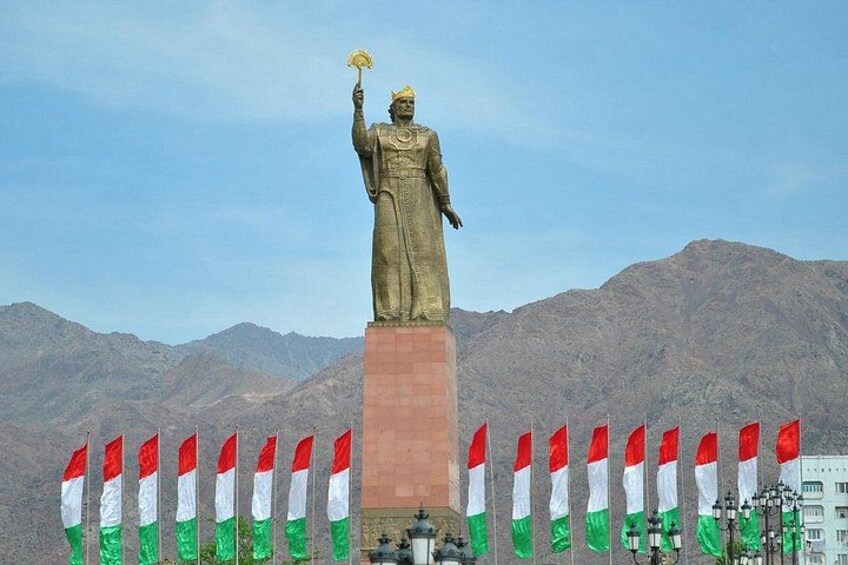 Une statue coiffée d’une couronne, tenant un sceptre, et entourée de drapeaux. 5