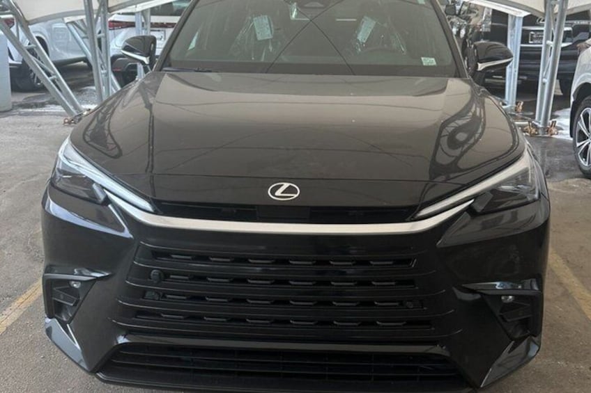Un SUV Lexus nero parcheggiato in un parcheggio insieme ad altri veicoli. 5
