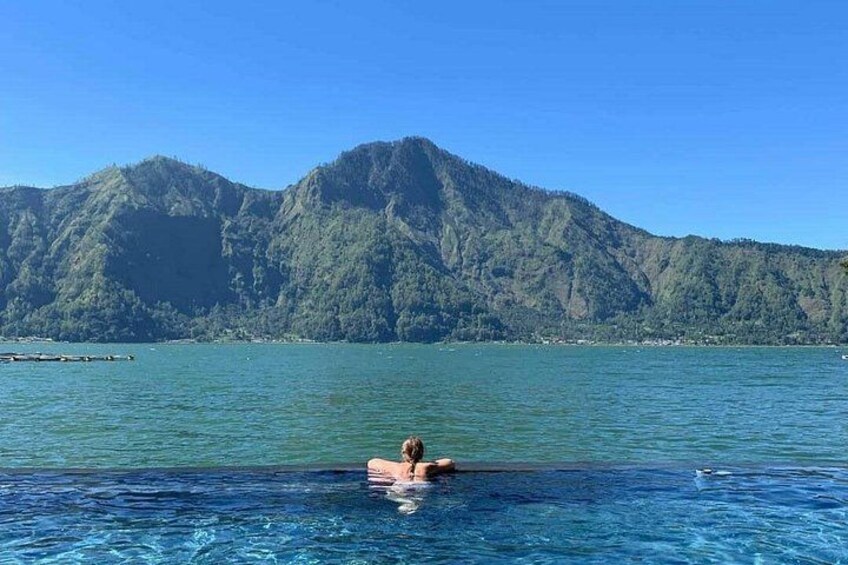 A person swimming in a pool with a mountain in the background. 2