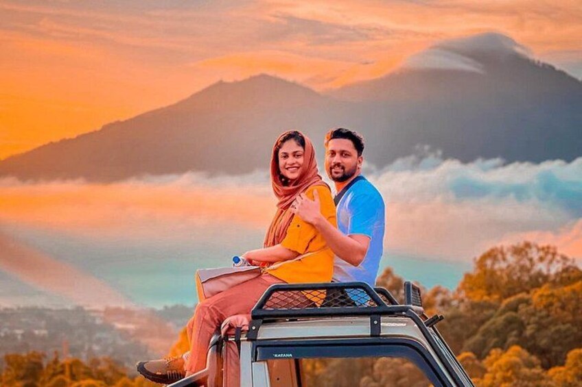 A couple on a vehicle with a mountainous landscape in the background. 5