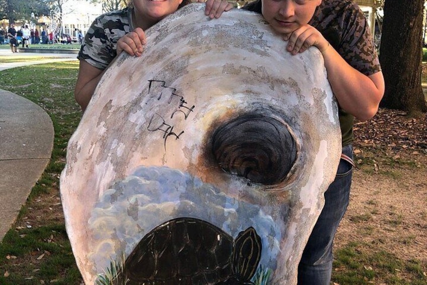 Eine große Skulptur mit spiralförmigem Design und Graffiti auf einer Parkbank. 4