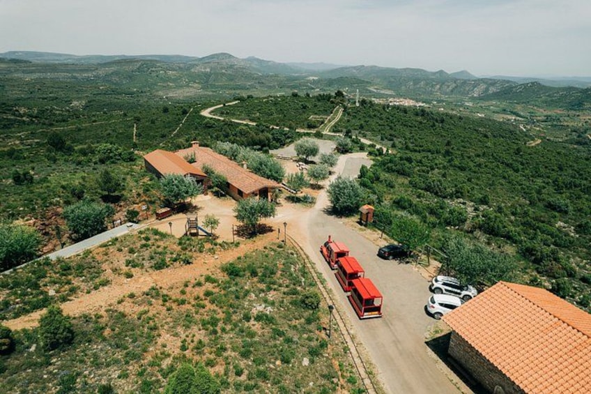 A rural landscape with a red bus, buildings, and a winding road. 3