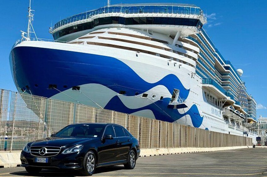 Un grand navire de croisière était amarré dans un port, et une voiture noire était garée devant. 2