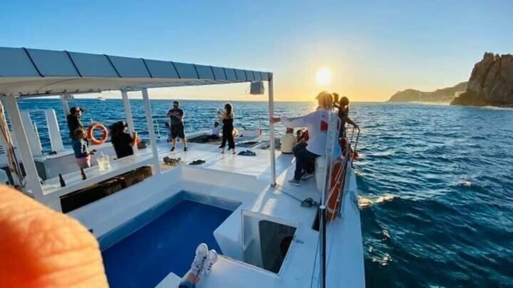 A boat with people on deck, a pool, and a rocky coastline in the background. 4