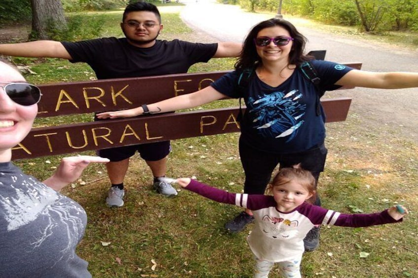 Una familia parada frente a un cartel que dice 'ARK FOR NATURAL PARK'. 4