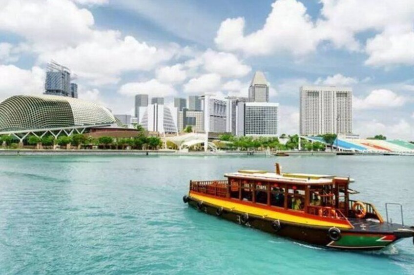 Un bateau sur une rivière turquoise, avec la silhouette d’une ville en arrière-plan. 5