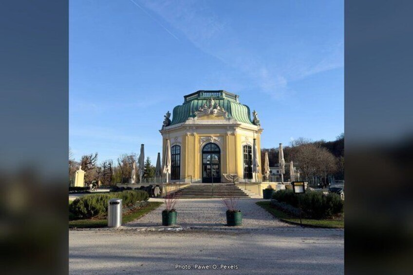 Un edificio in stile classico con tetto verde, una cupola centrale e una facciata simmetrica. 2