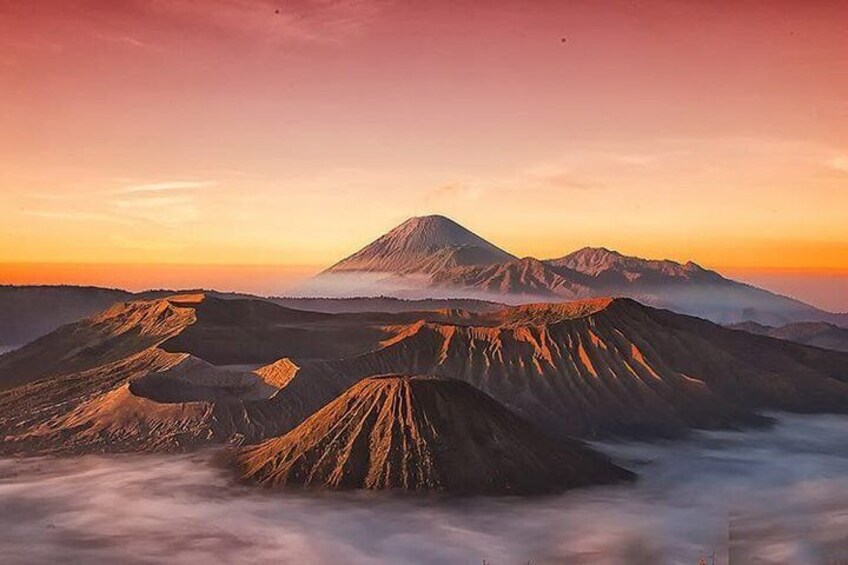 A mountain range at sunrise with a prominent peak and layered ridges. 2