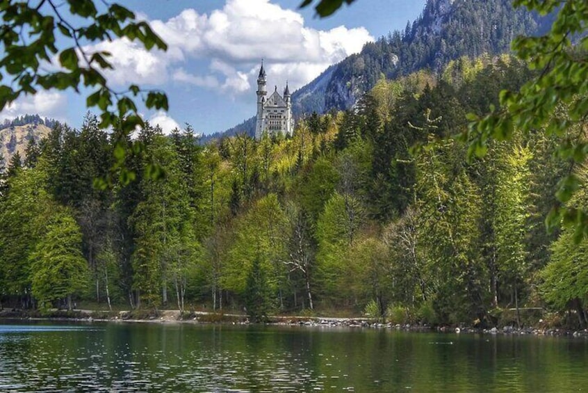 Un château perché sur une colline, entouré d’une forêt et bordé d’un lac. 1