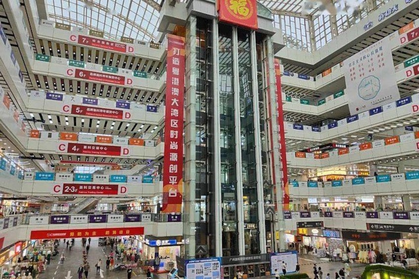 A multi-level shopping mall with numerous signs and banners. 2