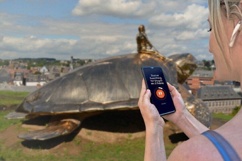 A person using a smartphone with a search bar for statues. 5