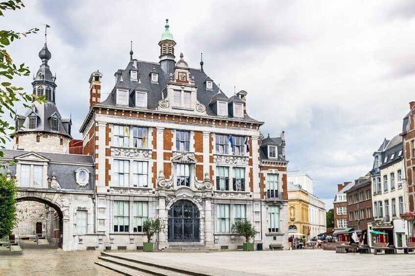 A historic building with ornate architecture, a large arched entrance, and a clock tower. 2