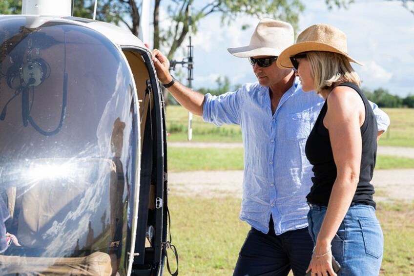 A man and a woman standing next to a vehicle with an open door. 2