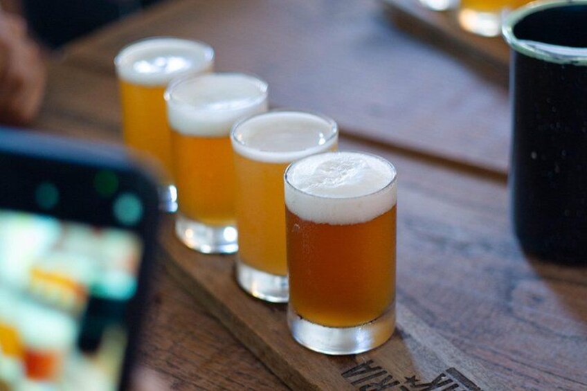 Quatre verres de bière sur un plateau en bois. 5