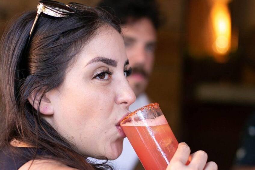 Une personne tenant une boisson rouge, agrémentée d’une garniture. 3